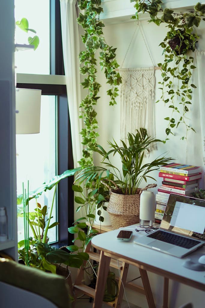 A cozy home office setup featuring a laptop, lush indoor plants, and a stylish interior.